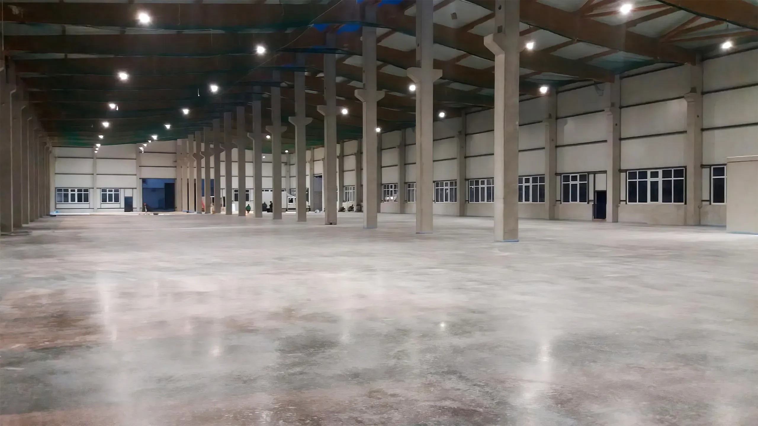 große Leichtbauhalle mit poliertem Betonboden und hohen Betonsäulen