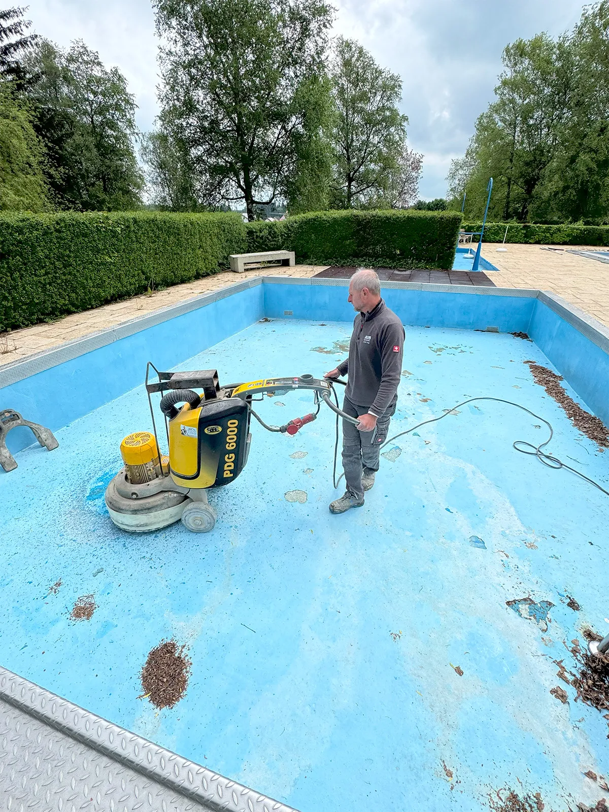 Schleifen eines Schwimmbeckens mit Schleifmaschine – Sanierung