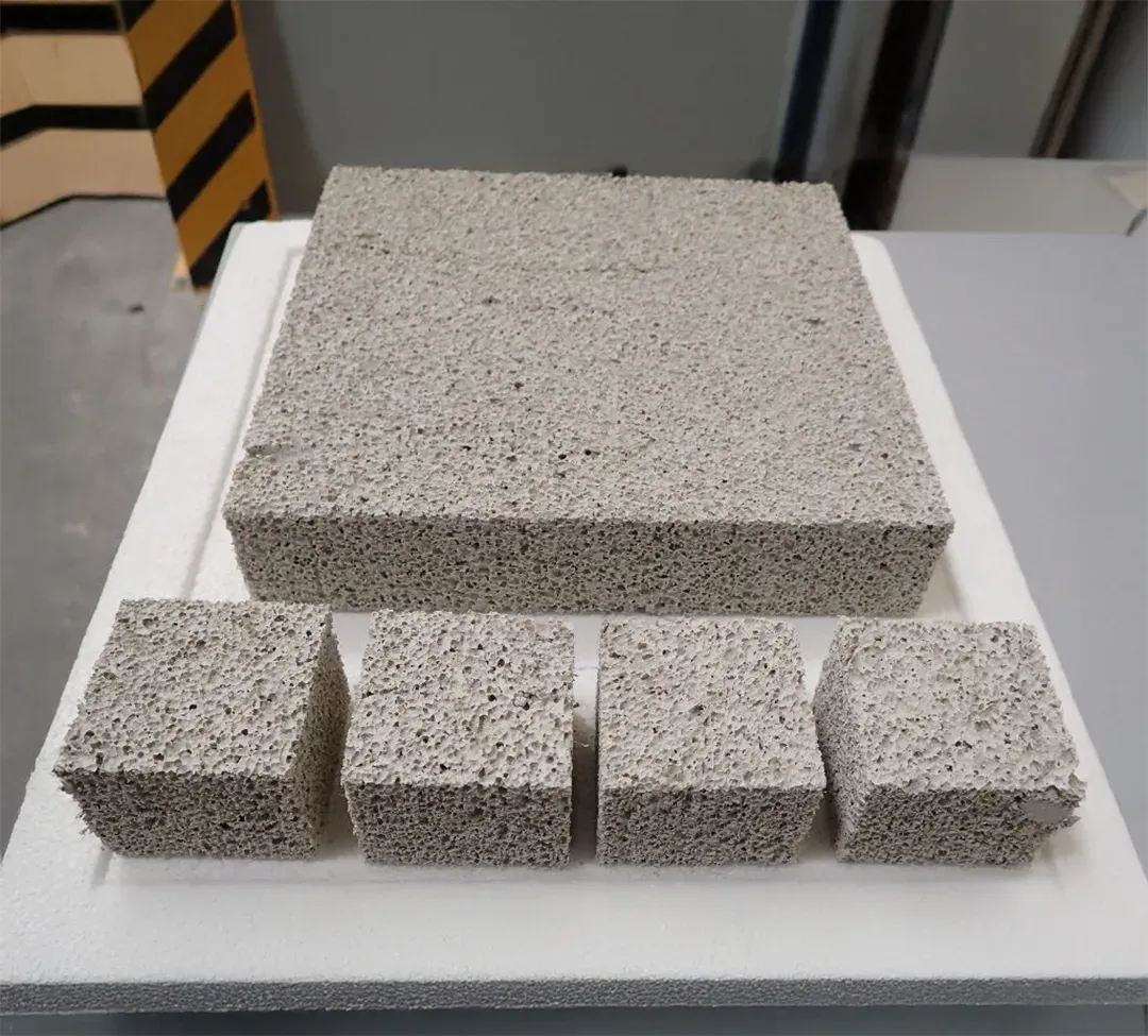 Verschiedene Blöcke porösen, grauen Dämmmaterials auf einer weißen Unterlage
