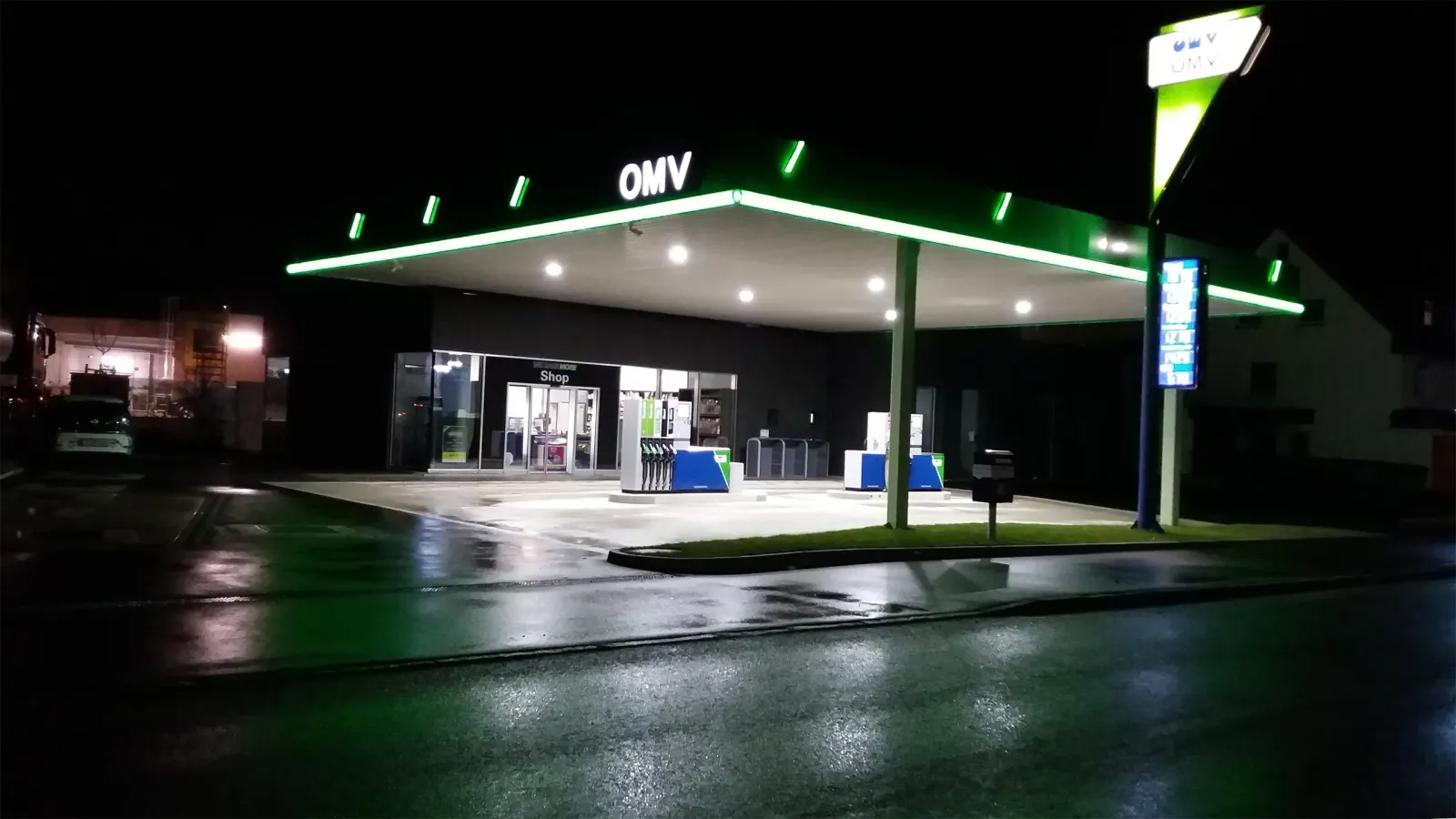 beleuchtete Tankstelle mit moderner Architektur in der Nacht