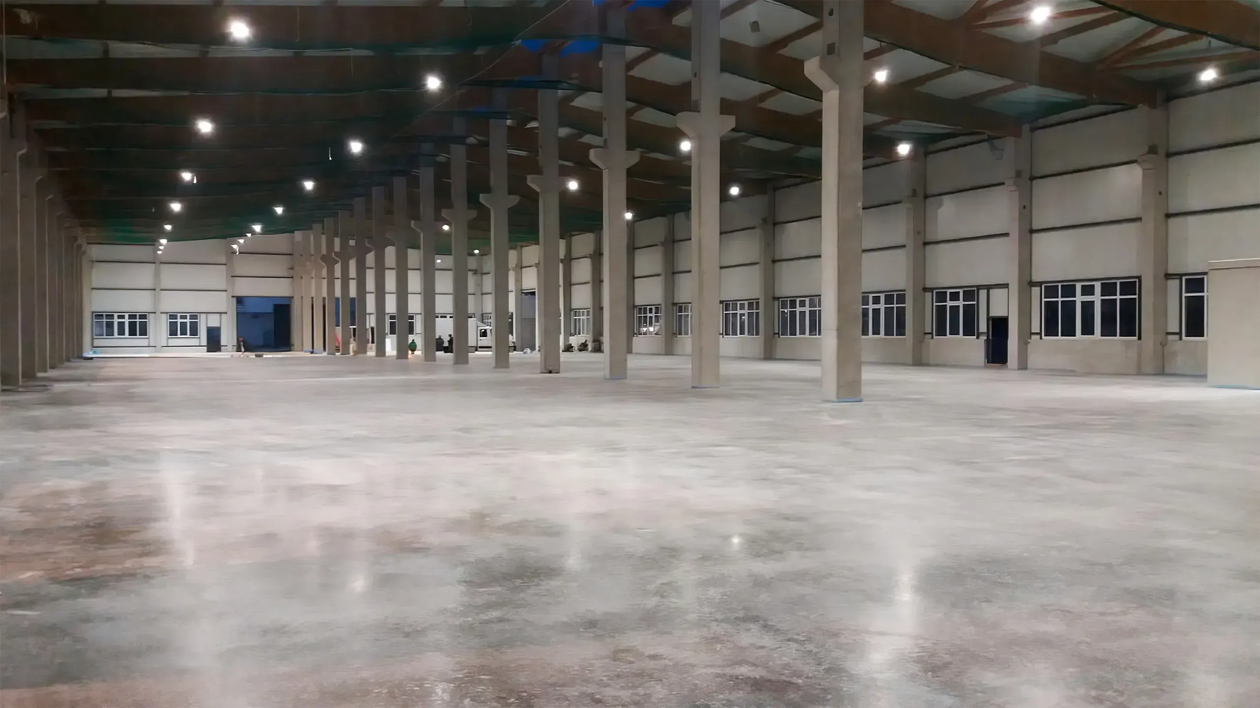 große Leichtbauhalle mit poliertem Betonboden und hohen Betonsäulen