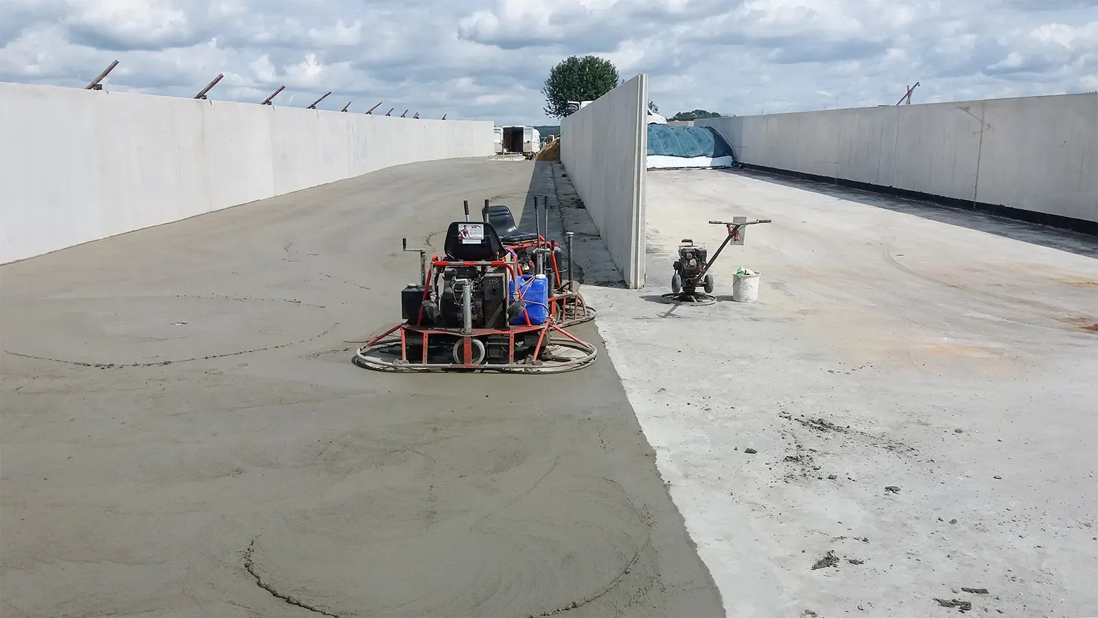 große Außenfläche aus Beton mit Glättmaschinen und hohen betonierten Wänden